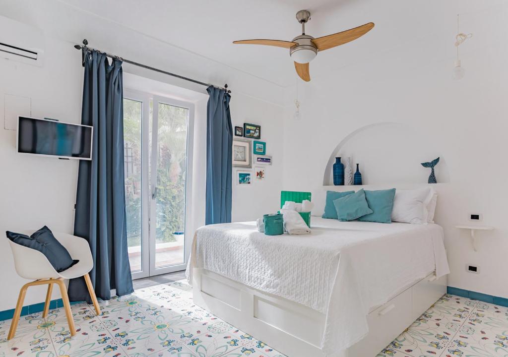 a bedroom with a white bed and a window at LA VILLA AURELIA in Bacoli