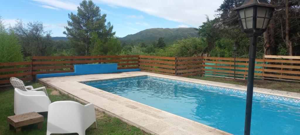 a swimming pool in a yard with a fence at Cabañas Del Alto in Villa Giardino