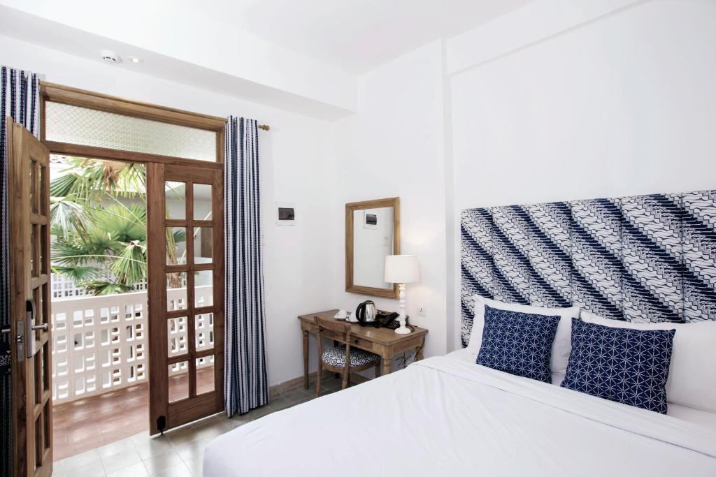 Postel nebo postele na pokoji v ubytování Adhisthana Hotel Yogyakarta