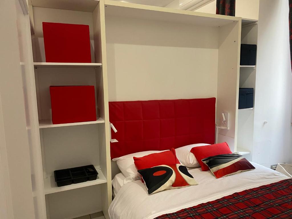 a bed with a red headboard in a room at La perla del Colosseo in Rome