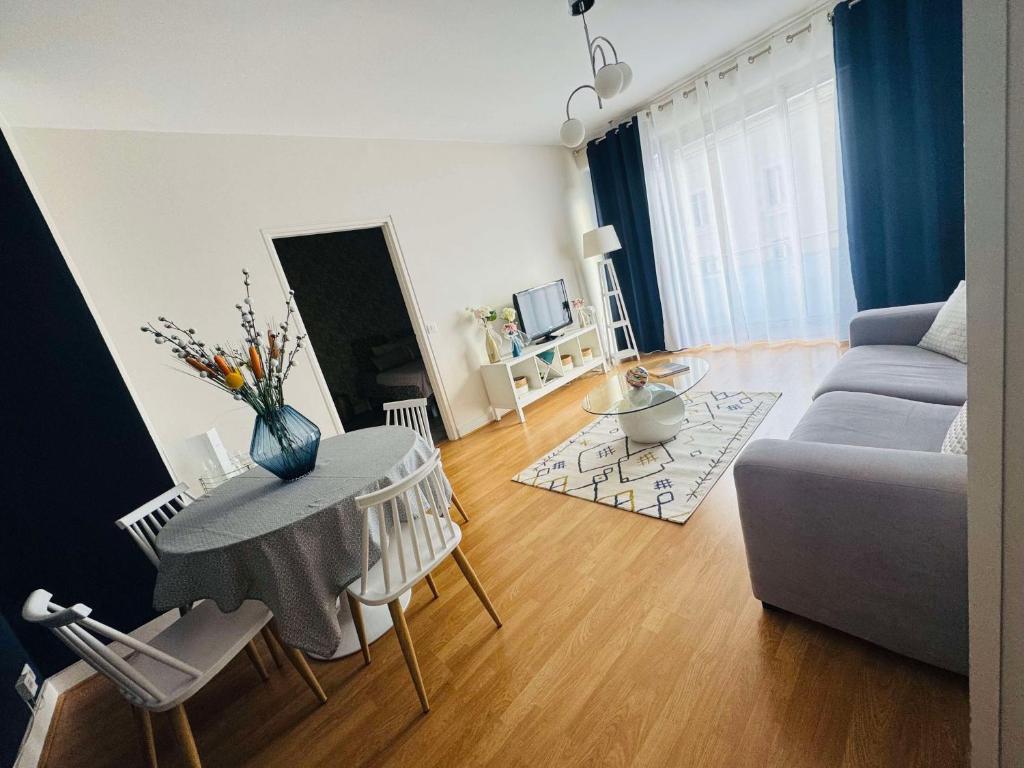 a living room with a table and a couch at Le 21 Avenue de Champagne in Épernay