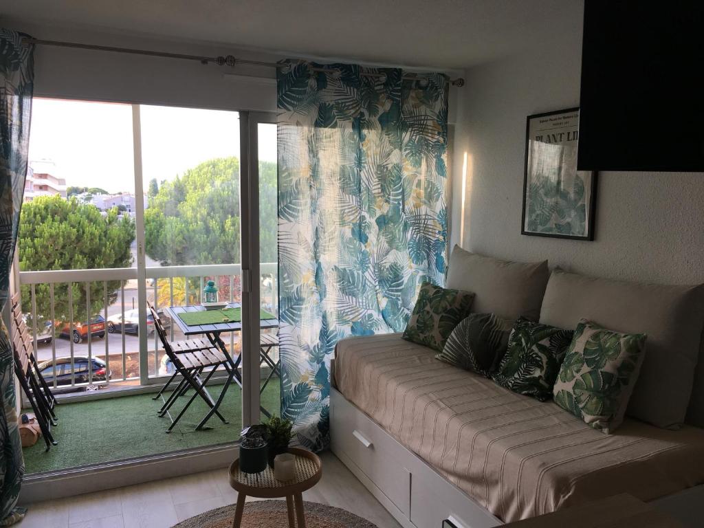 un salon avec un canapé et une grande fenêtre dans l'établissement Les pieds dans l'eau, au Grau-du-Roi