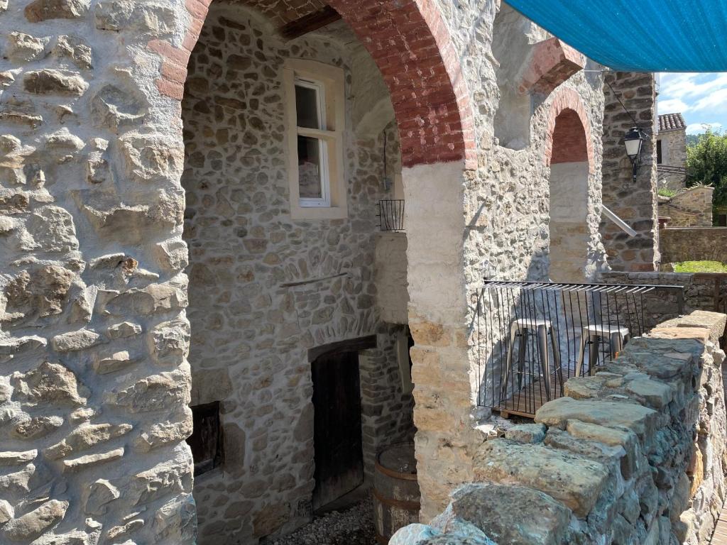 - un bâtiment en pierre avec une fenêtre et un mur en pierre dans l'établissement Les Gîtes du Soleil Vert, à Meyrannes