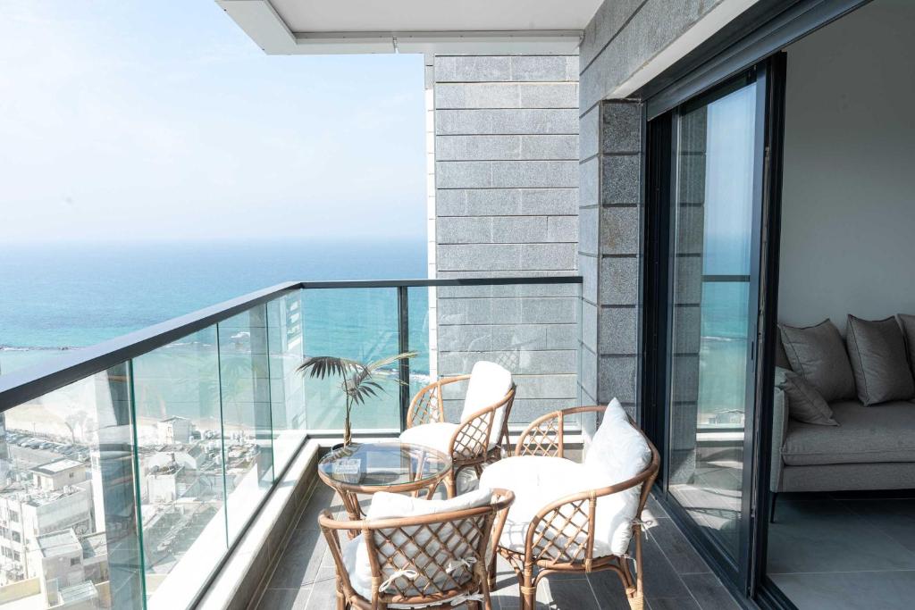een balkon met stoelen en een tafel bij O&O Group Luxury Tower 4BR Panoramic Sea Views in Bat Yam