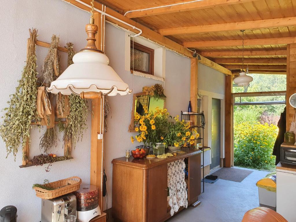 una cucina con tavolo e fiori sul muro di 'PRZY PARKU' pokoje gościnne u zielarki a Stegna