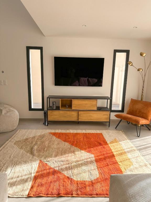 un salon avec une télévision à écran plat sur un mur dans l'établissement Villa d'architecte, à Port-la-Nouvelle