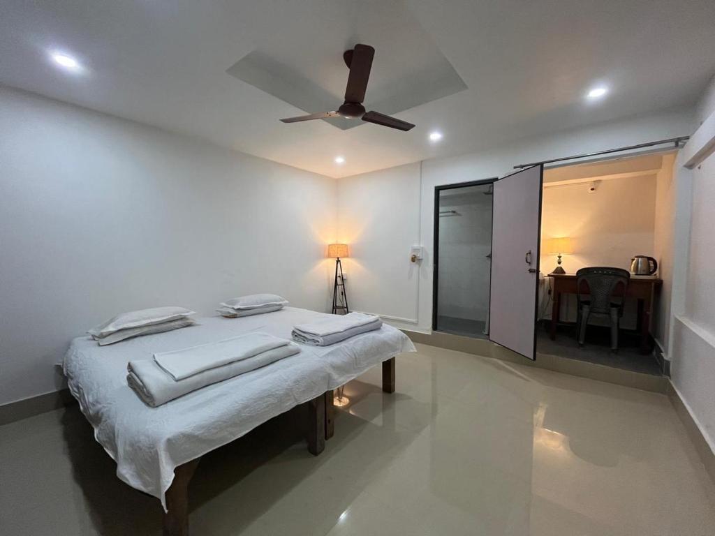 Un dormitorio con una cama y un ventilador de techo. en Nagaon Homestay, en Nowgong