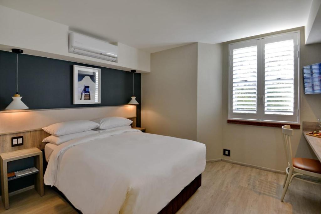 ベルビルにあるTown Lodge Bellvilleの大きな白いベッドと窓のある寝室