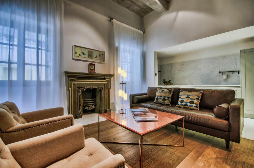 sala de estar con muebles de cuero y chimenea en 10 Strait Street Apartments, en La Valeta