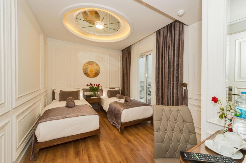 イスタンブールにあるダークメン ホテル2のベッド2台とデスクが備わるホテルルームです。