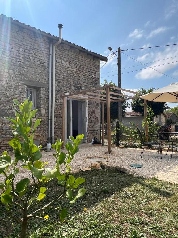 Cette maison en briques dispose d'une terrasse et d'un parasol. dans l'établissement Maison Vigneronne - Stay on a vineyard, in the winegrowers cottage, à Savigné