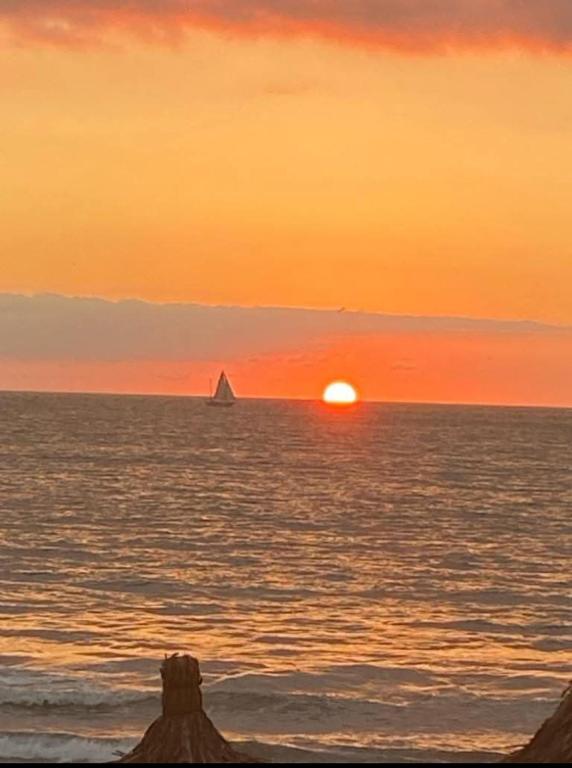 a sunset over the ocean with a boat in the water at Habitación en Condominio frente al mar Nuevo Vallarta in Nuevo Vallarta