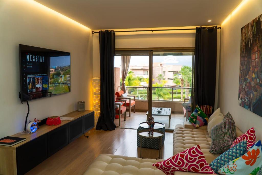 a living room with a couch and a television at Marrakech Golf City Prestigia 4 minutes du centre in Marrakech