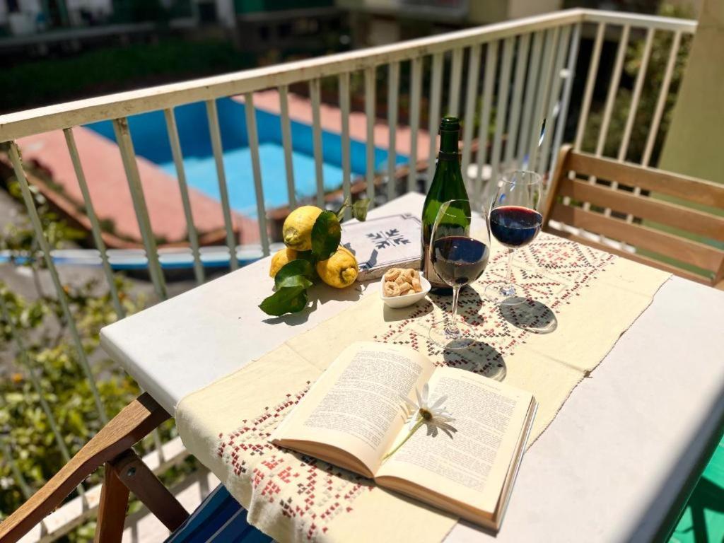 Una mesa con un libro abierto y copas de vino. en home & pool 2, en Sorrento