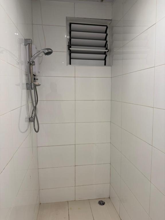 un bagno piastrellato bianco con finestra e doccia di Island Payless a Nadi