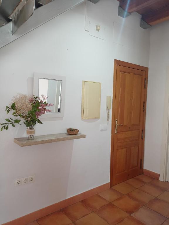 a hallway with a mirror and a wooden door at Apartamento La Carmela in Utrera
