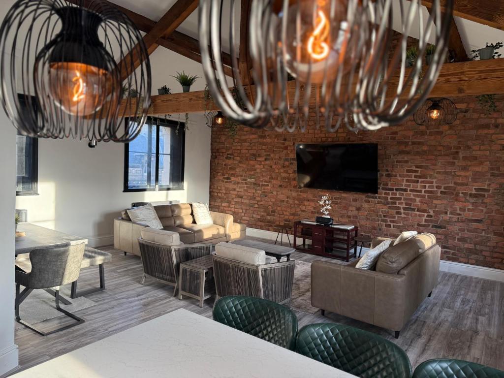 リバプールにあるStylish city centre Penthouseのレンガの壁のリビングルーム(ソファ付)
