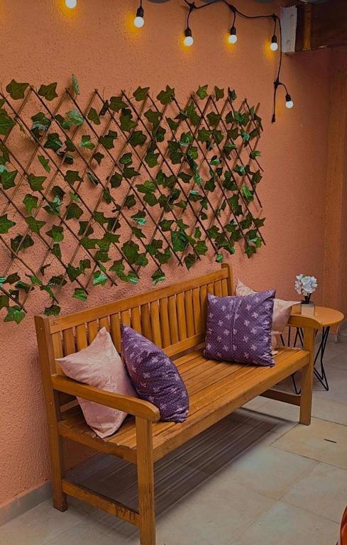 a wooden bench with pillows against a wall at Le house hostel in São Paulo