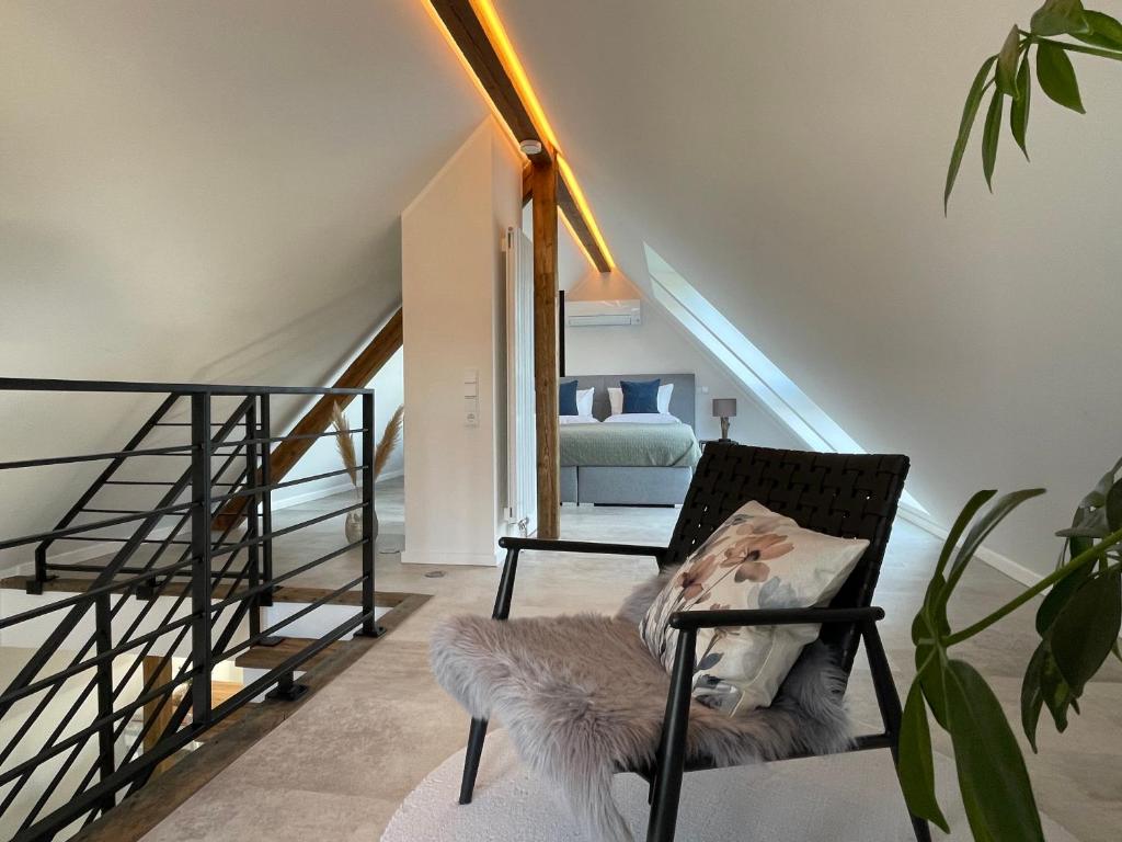 a living room with a chair and a staircase at FeWo „Am alten Eifelhaus“ in Monschau