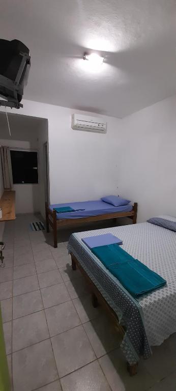 pokój z dwoma łóżkami i telewizorem z płaskim ekranem w obiekcie Pousada Abais-Inn w mieście Cabo de Santo Agostinho