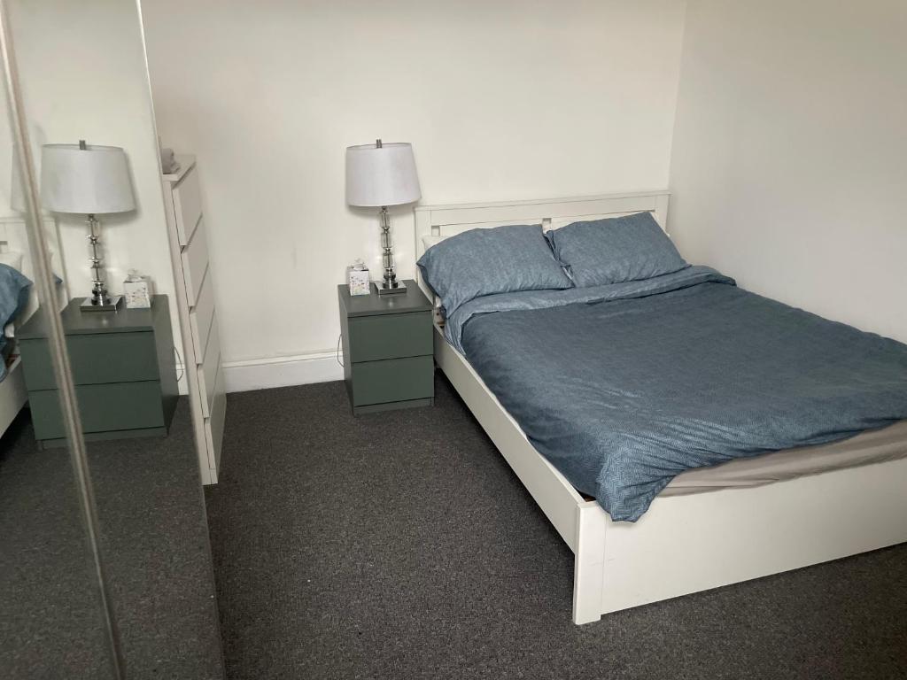 a bedroom with a bed and two night stands at Room close to City and Hospital in Cardiff