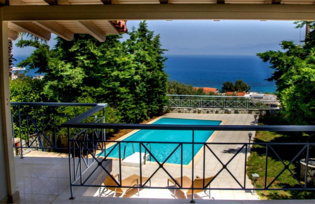 a balcony with a view of a swimming pool at Corinthian Residence in Melíssion
