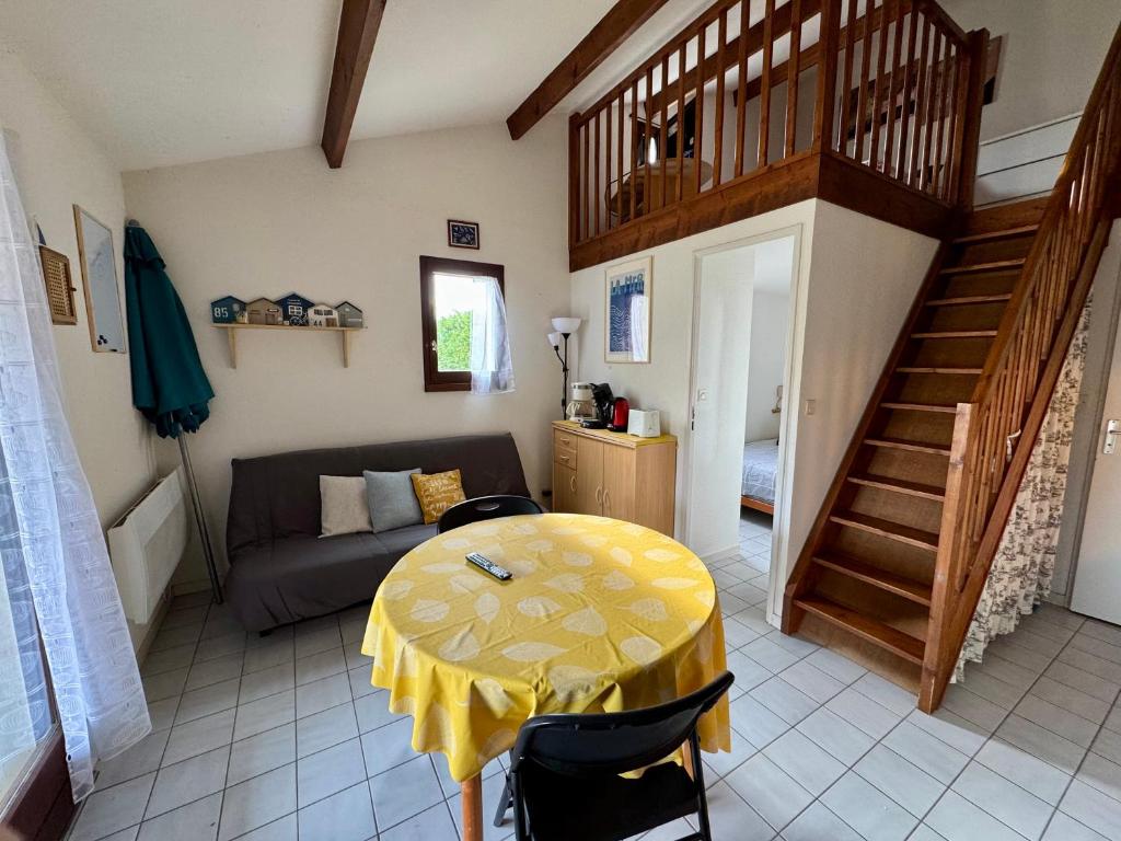 un salon avec une table et un canapé dans l'établissement Maison Piscine Clim à 2 pas de la Mer, à Saint-Vincent-sur-Jard