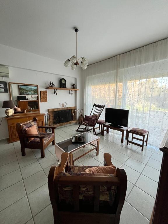 a living room with couches chairs and a tv at Panormitis House in Kefalos