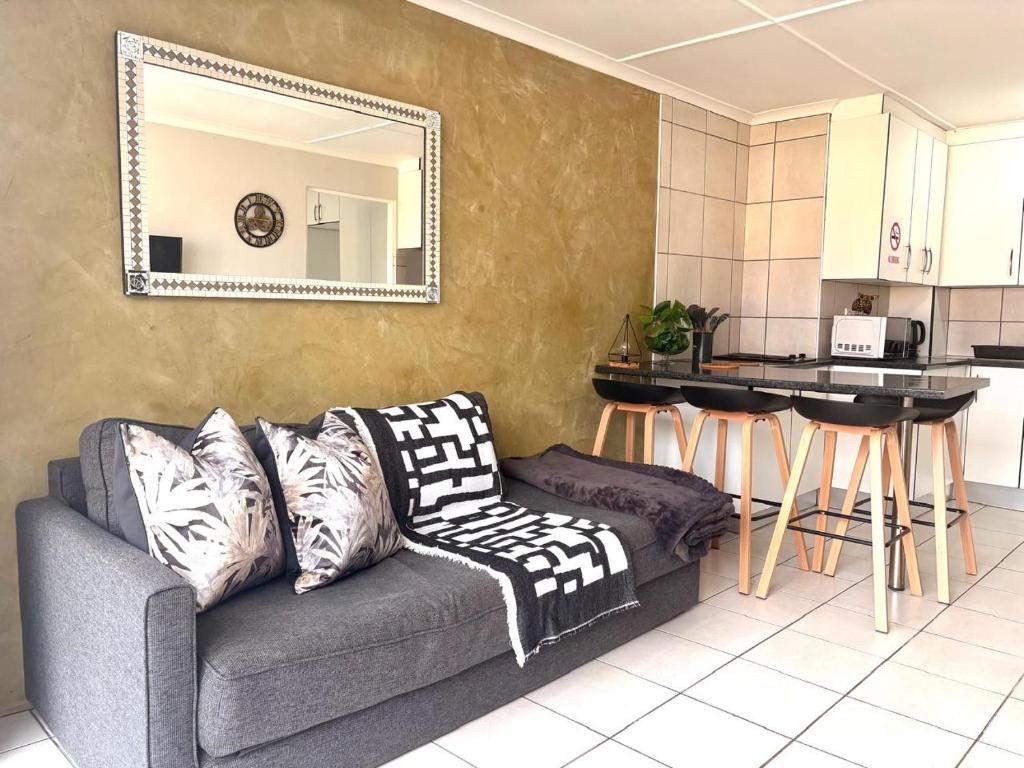 a living room with a couch and a kitchen at Sea Breeze Manor - Gold unit in East London