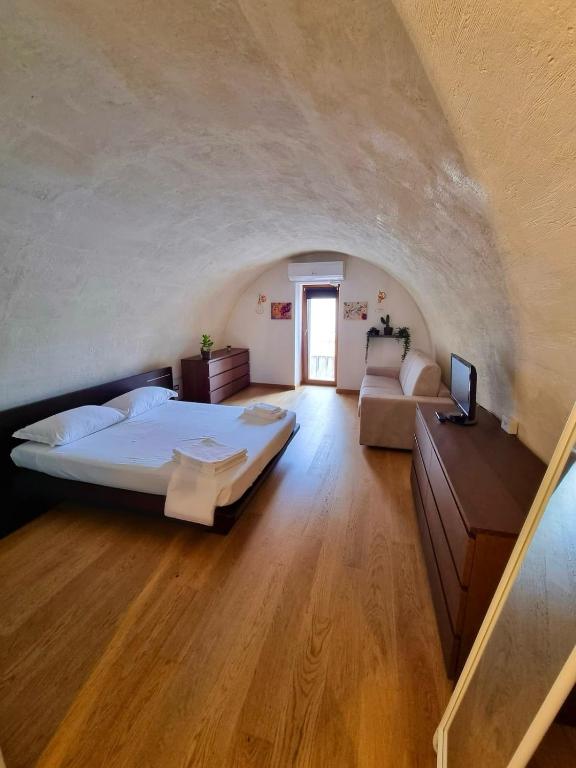 een grote slaapkamer met een bed en een bank bij Bellavita Rooms-Matera Arco 34 in Matera