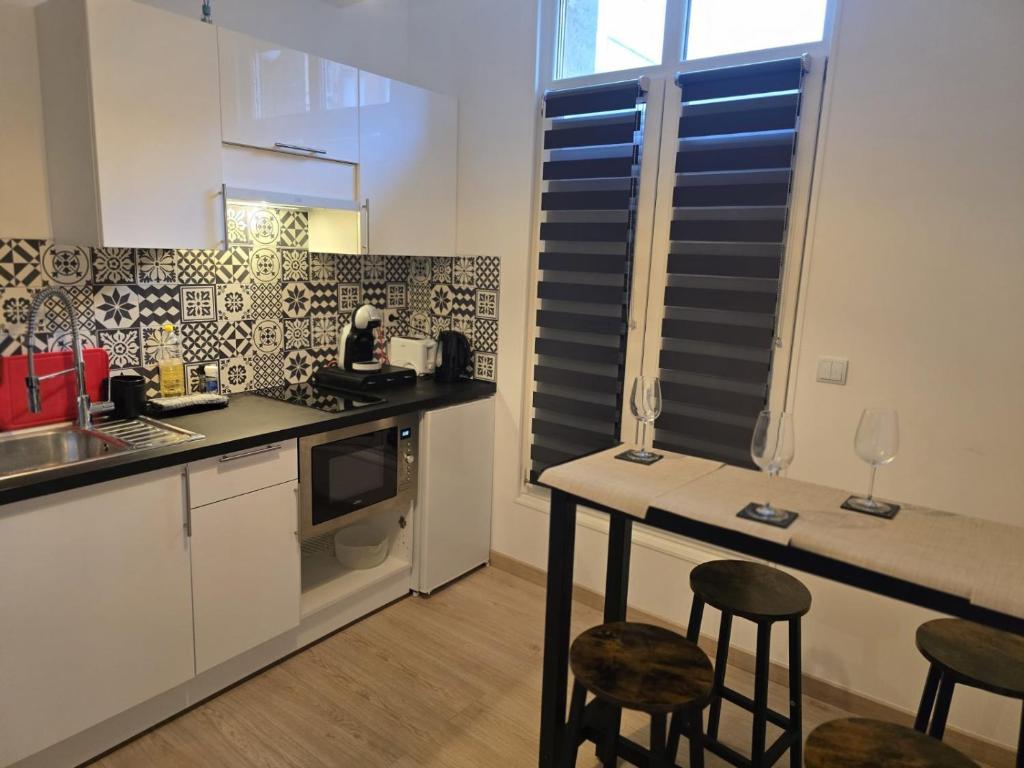 une cuisine avec un comptoir et des tabourets dans une pièce dans l'établissement Hamdan Suite, à Reims