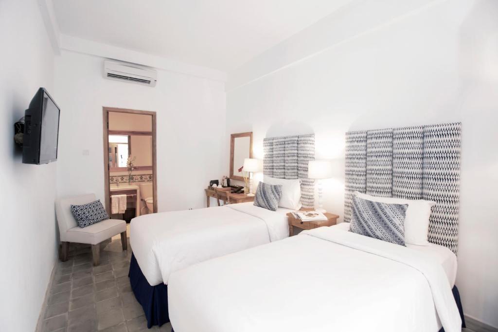 Postel nebo postele na pokoji v ubytování Adhisthana Hotel Yogyakarta