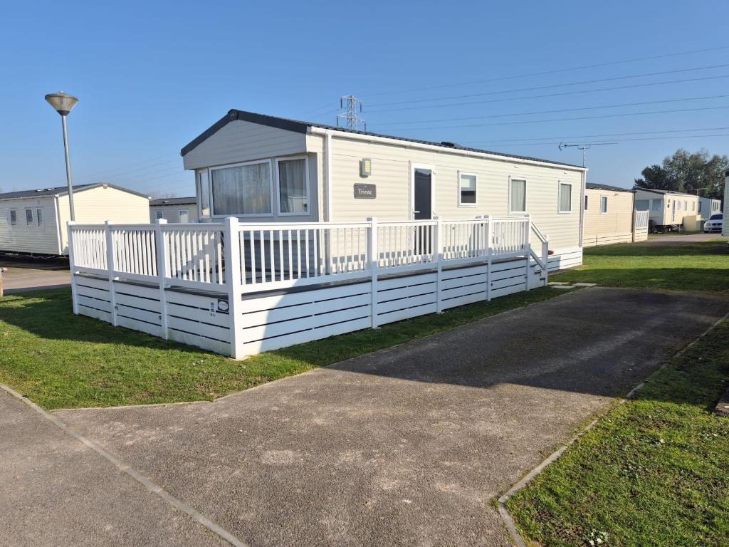 a mobile home with a white fence in front of it at 3 Bed Holiday Home - Birchington Vale in Margate