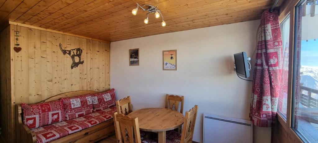 Cette petite chambre comprend une table, une table et des chaises. dans l'établissement Résidence Chamois - Studio pour 4 Personnes 084, à Aime La Plagne