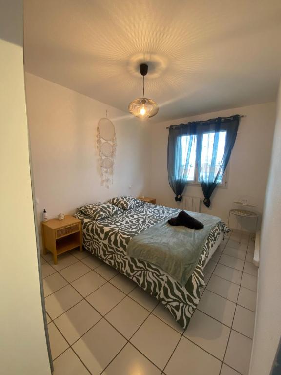 une chambre avec un lit, une table et une fenêtre dans l'établissement Le calme à proximité de la mer, à Canet