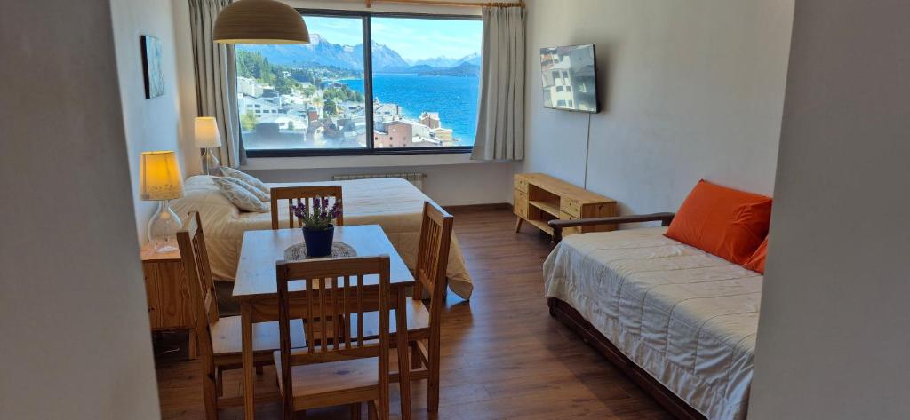 un soggiorno con letto, tavolo e finestra di Piso 8 Bariloche a San Carlos de Bariloche