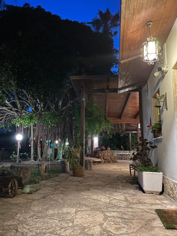 un patio de una casa por la noche con luz en Al giardino, en Taranto