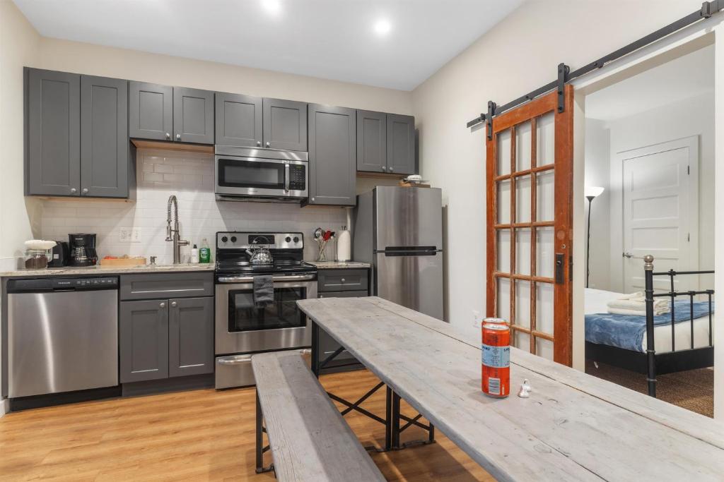 a kitchen with stainless steel appliances and a wooden table at Lovely 1-BR Suite in the Heart of Adams Morgan in Washington, D.C.