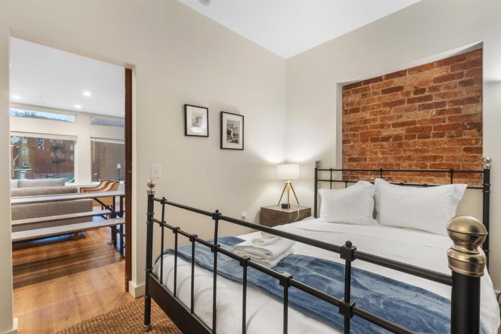a bedroom with a bed and a brick wall at Lovely 1-BR Suite in the Heart of Adams Morgan in Washington, D.C.
