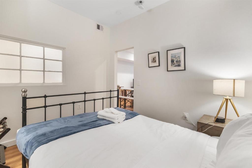 a white bedroom with a bed and a window at Lovely 1-BR Suite in the Heart of Adams Morgan in Washington, D.C.
