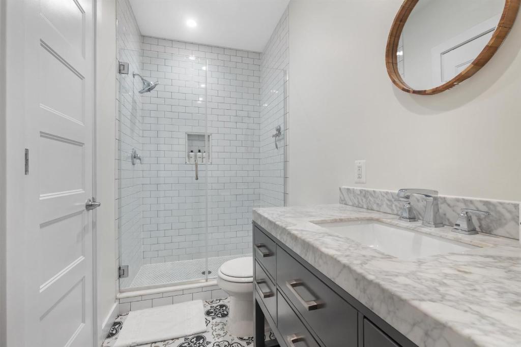 a white bathroom with a sink and a toilet at Lovely 1-BR Suite in the Heart of Adams Morgan in Washington, D.C.