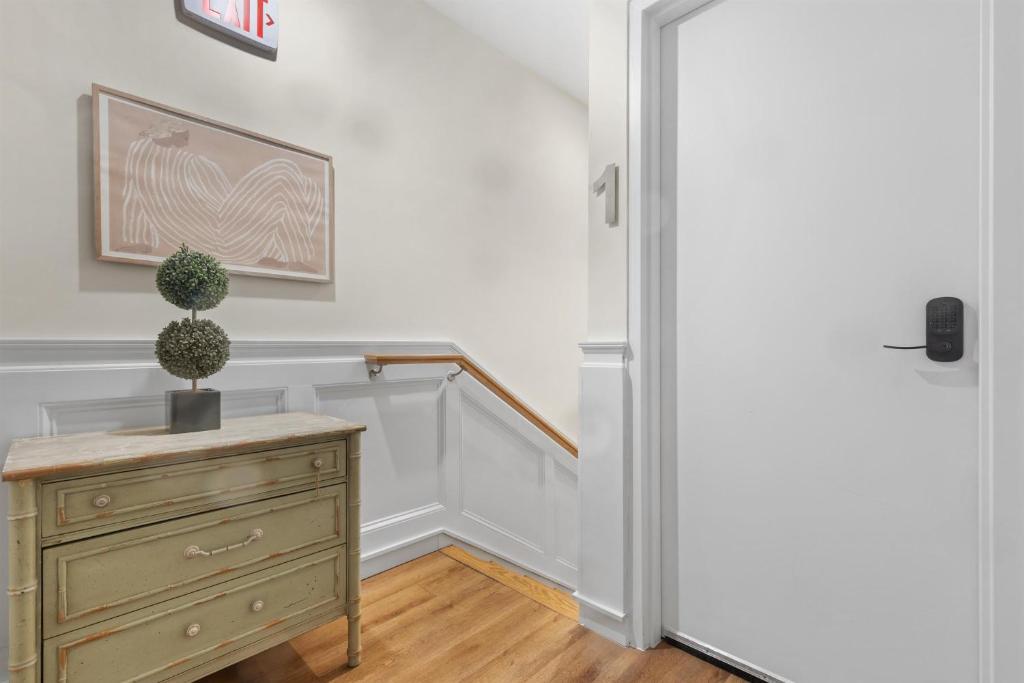 a hallway with a dresser and a potted plant next to a door at Lovely 1-BR Suite in the Heart of Adams Morgan in Washington, D.C.