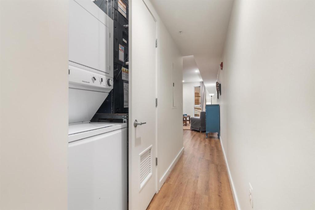 a kitchen with white cabinets and a wooden floor at 1-BR Getaway in the Heart of Adams Morgan in Washington, D.C.
