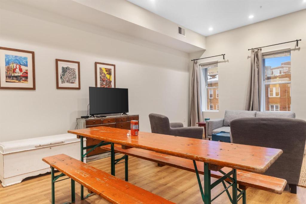 a living room with a table and a tv at Heart of Adams Morgan Walk Everywhere in Washington, D.C.