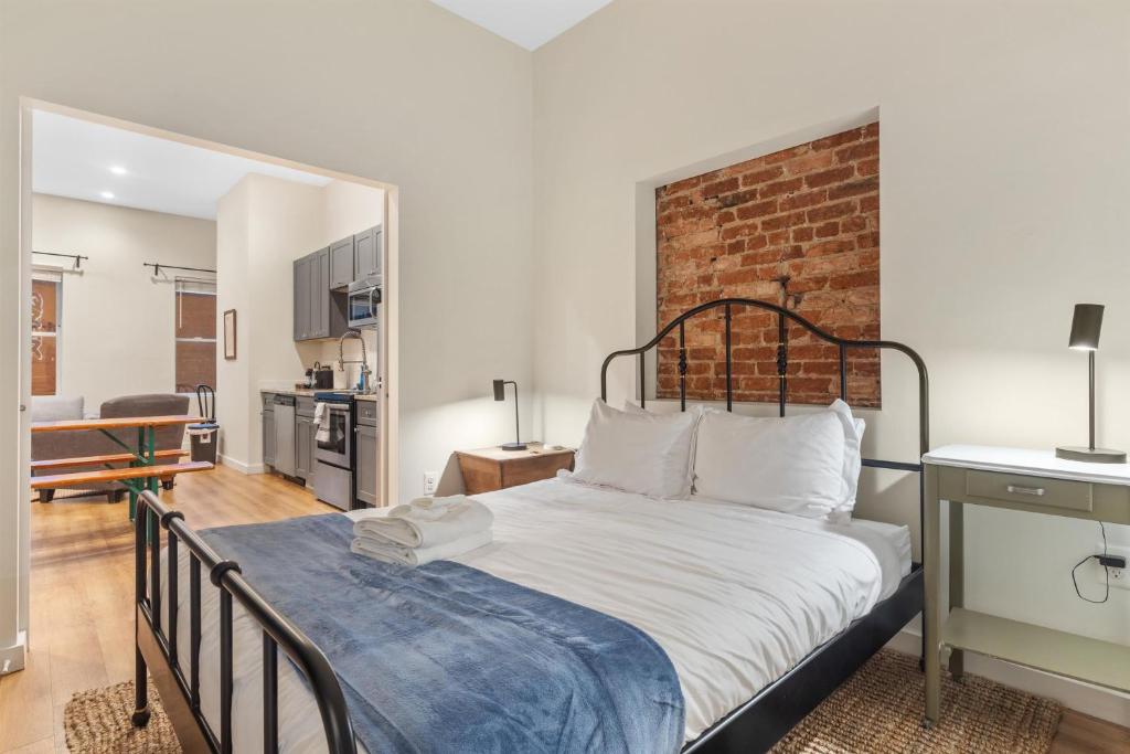 a bedroom with a bed and a brick wall at Heart of Adams Morgan Walk Everywhere in Washington, D.C.