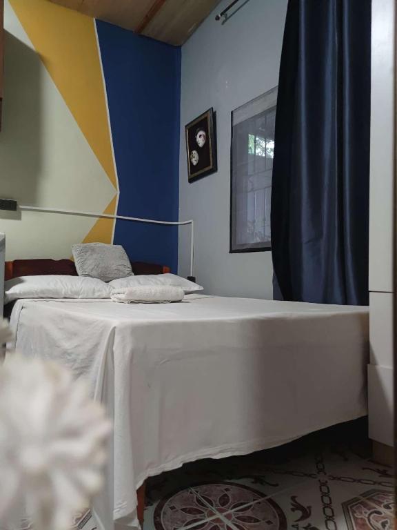 Un dormitorio con dos camas y una pared azul. en Transient Siete Barcelone B&B -Studio Type Valleyhomes Patul, en Plaridel