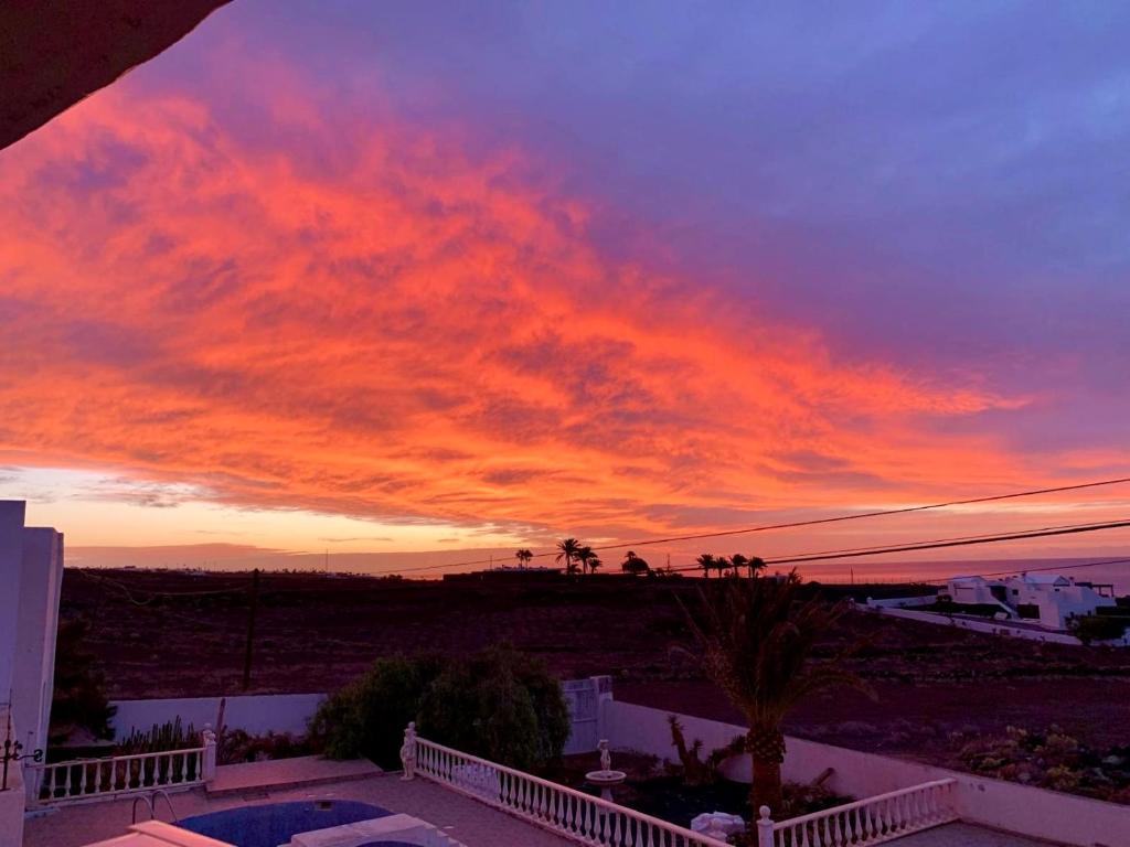 una vista sul tramonto dal balcone di una casa di Finca PiedraNegra a Tías