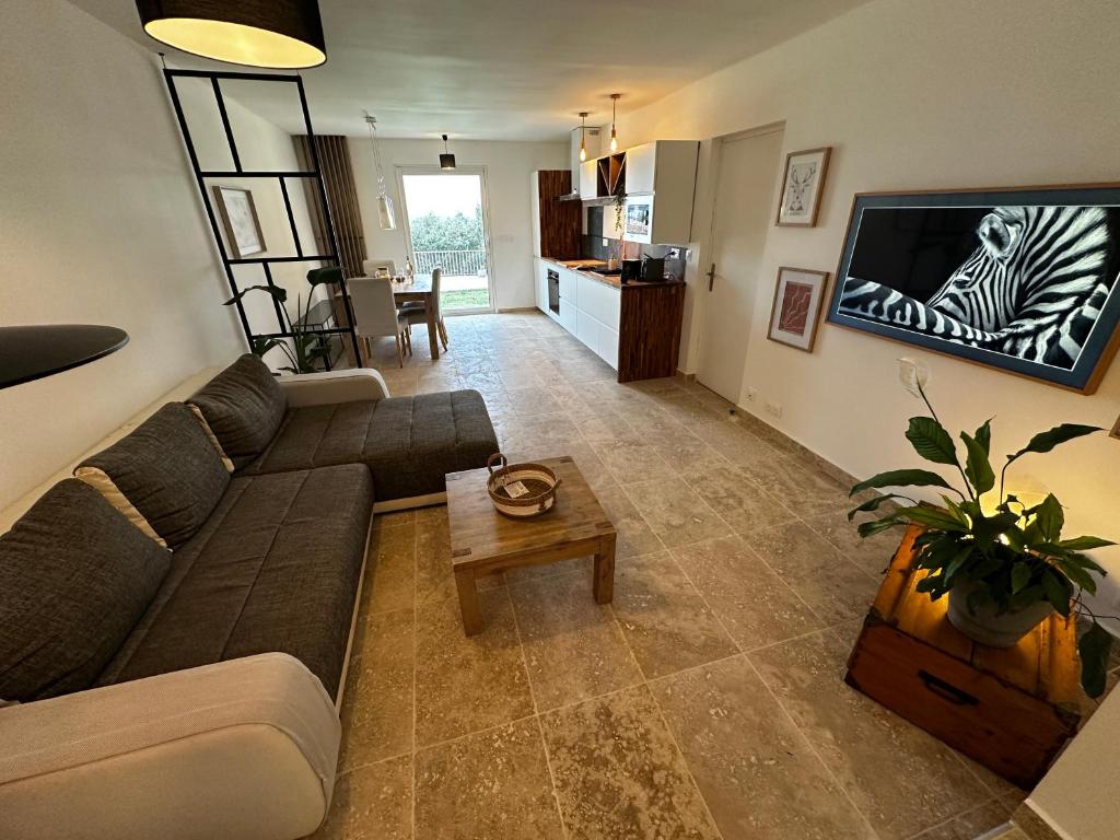 Una sala de estar con un sofá y un televisor. en Villa Horizons - Grande maison vue mer avec piscine 15mn à pieds de la plage, en La Seyne-sur-Mer