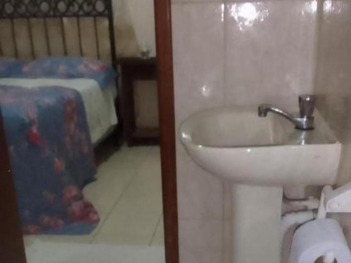 a bathroom with a sink and a bed at Hospedaria meu Lar in Rio das Ostras