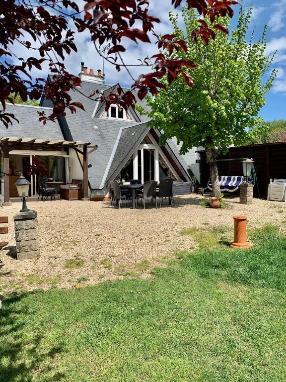une maison avec une table, des chaises et un arbre dans l'établissement La Bussière, à La Bussière